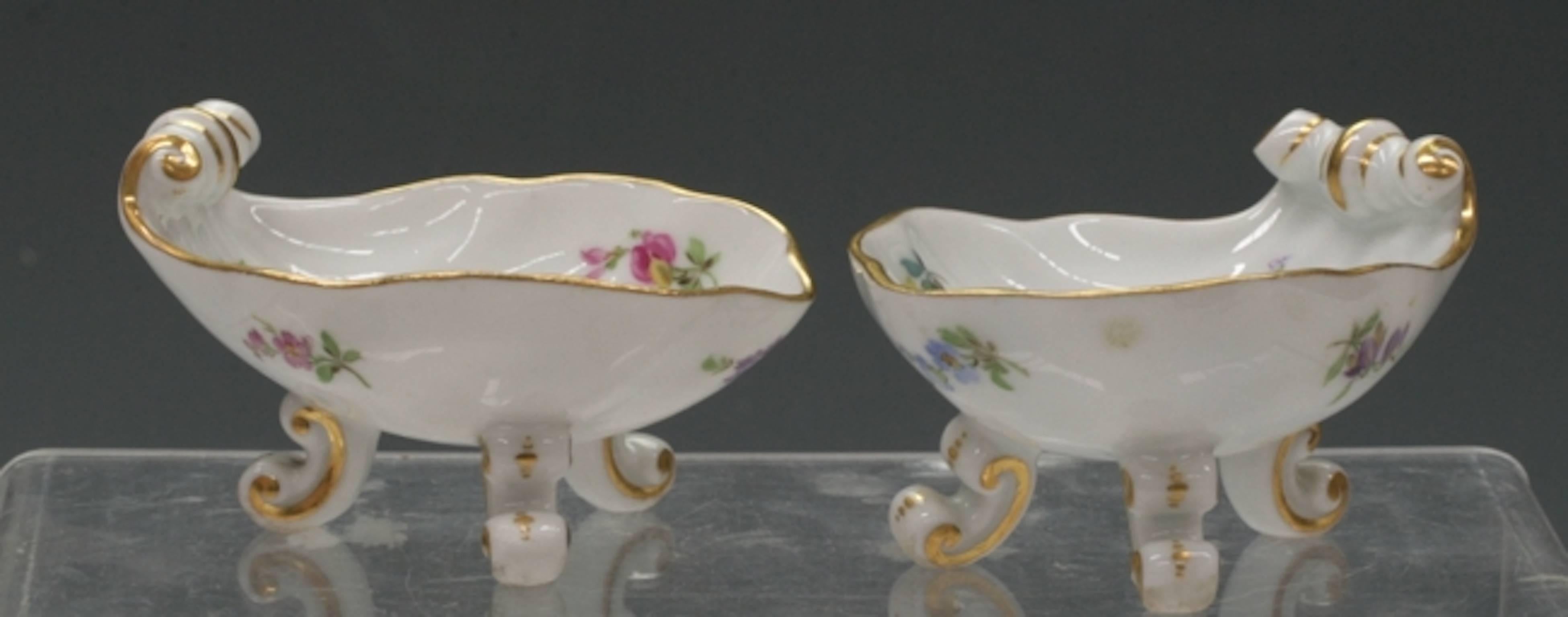 Meissen set includes two footed creamers and two footed dishes with tray. Tripod legs decorated with floral sprays. Blue cross mark on base.
Measure: Creamers 2.63