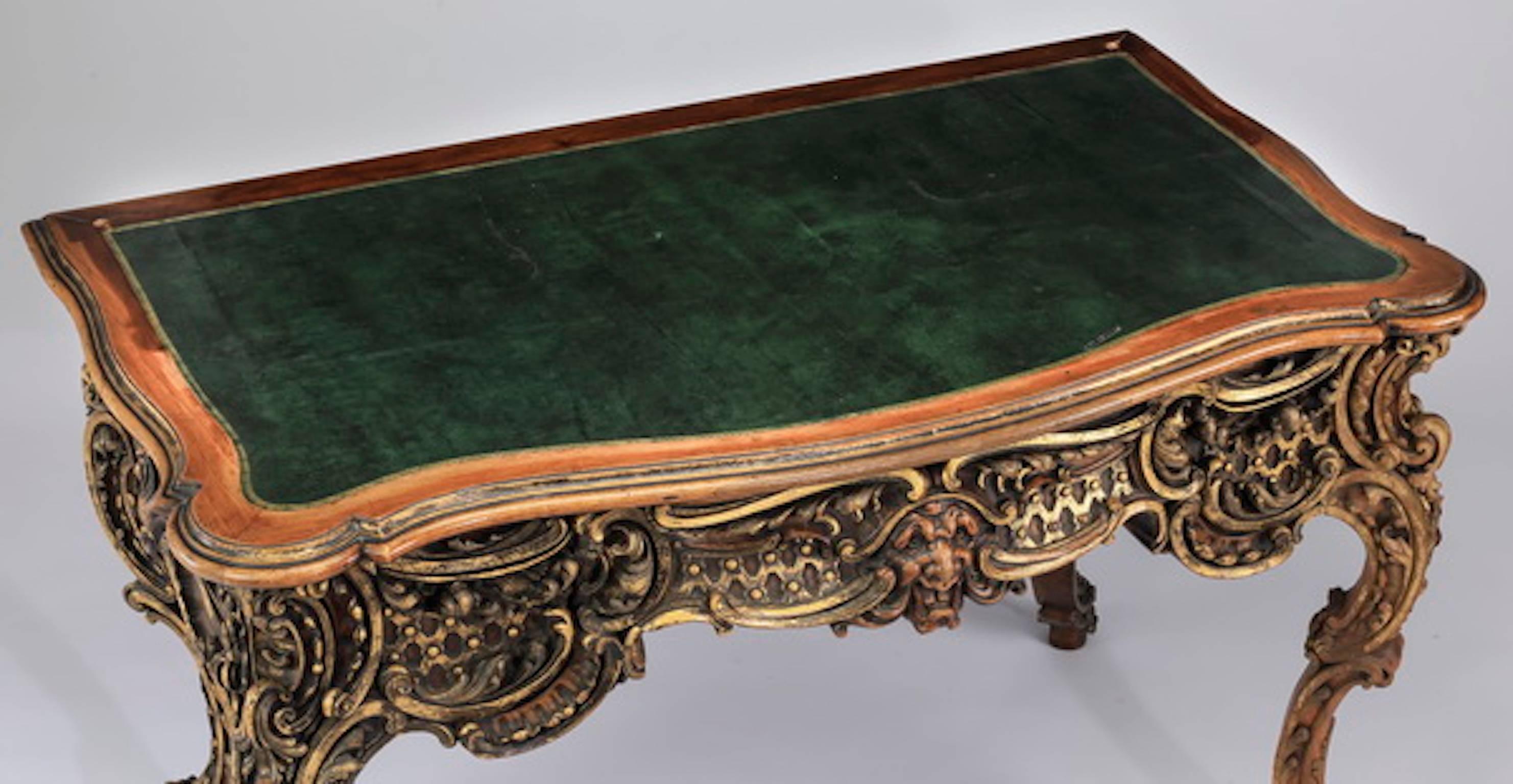 French carved walnut bonheur-du-jour, early 20th century, having a gilt accented pierced and carved arched shell crest, flanked by scrolling acanthus and parquetry inlaid shelves, surmounting a shelf flanked by four gilded and shaped drawers,