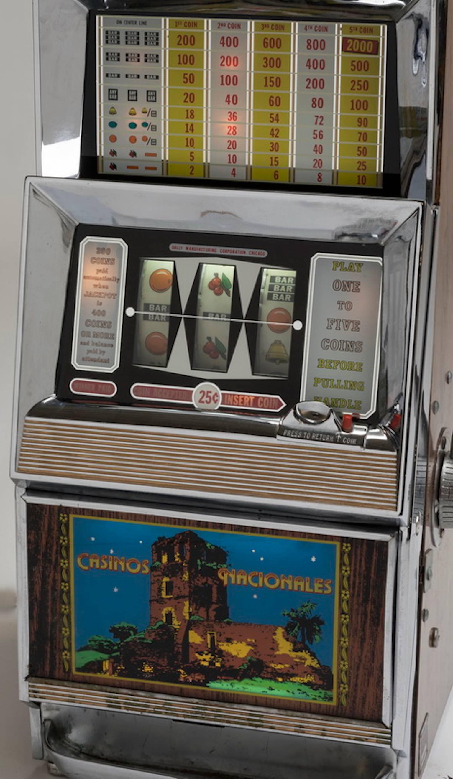 Vintage Bally coin operated multiplay slot machine, circa 1960, having three reels and taking up to five quarters per play, with a side pull lever and reverse painted lower panel depicting the 'Casinos Nacionals'