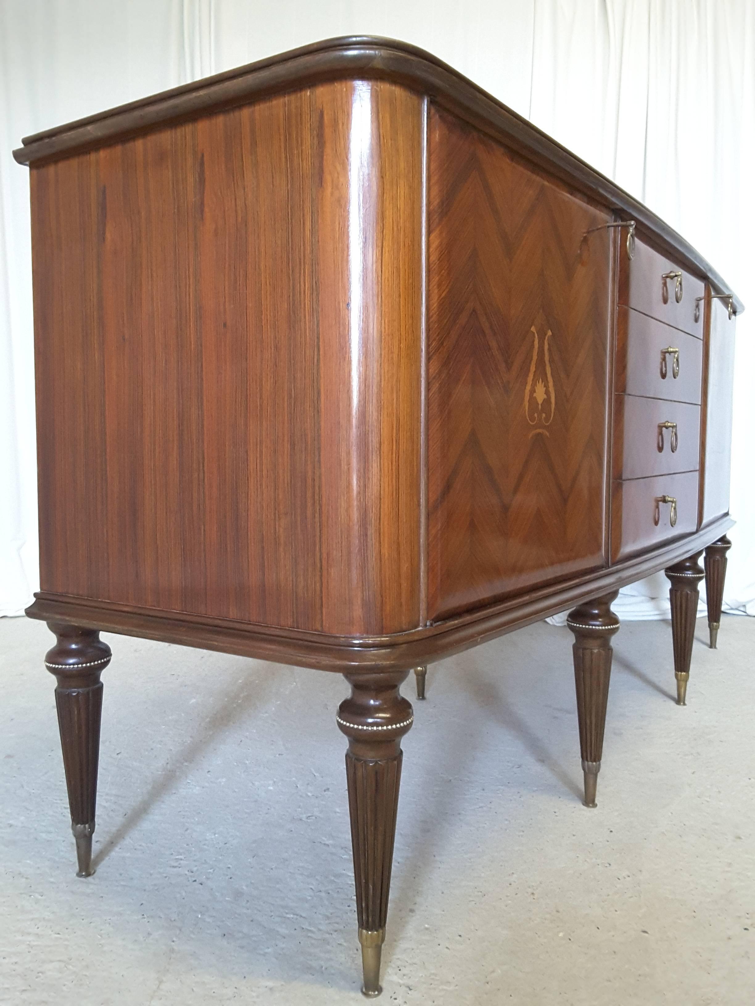 Italian sideboard inlaid with herringbone rosewood. Two doors with shelved internal cupboards and four drawers to the center. The top is reverse painted glass with subtle coper tones to complement the rosewood. Original working locks and keys.