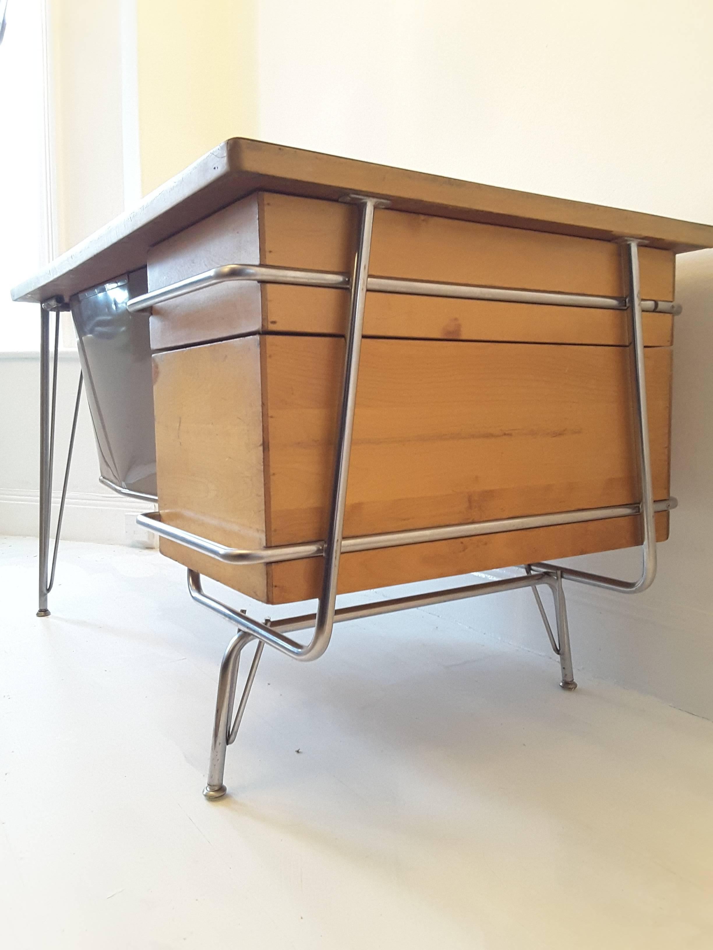 Mid-Century Modern Trimline desk designed by Kem Weber for Heywood Wakefield. Chromed tubular metal frame with solid birch drawers and original birch effect Formica top. Retains original working locks and key stamped Chicago Lock Co. Dismantles for