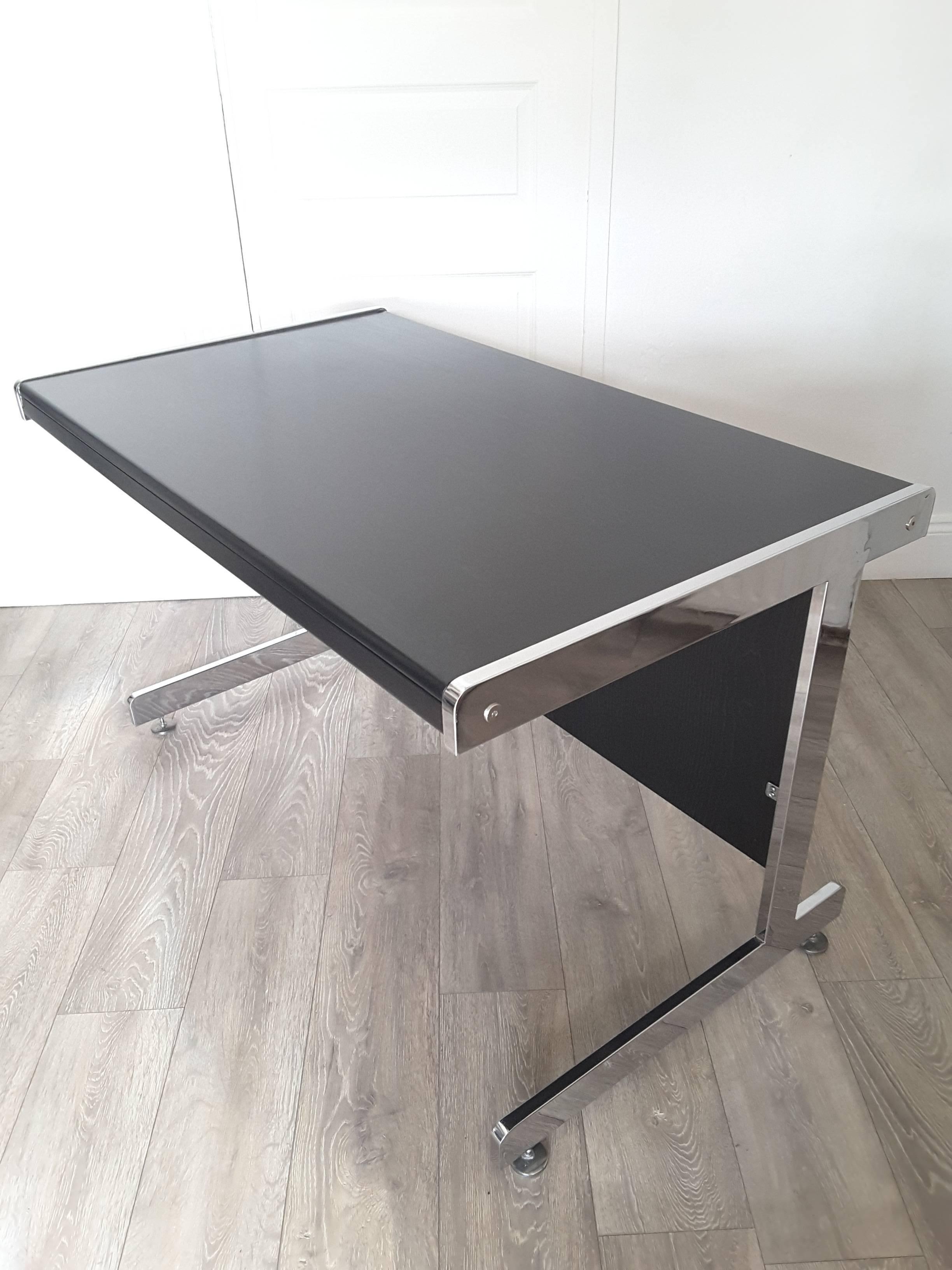 Mid-Century Modern Italian desk. Chrome supports with ebonized wood top and back panel. Adjustable pad feet. Dismantles for shipping.