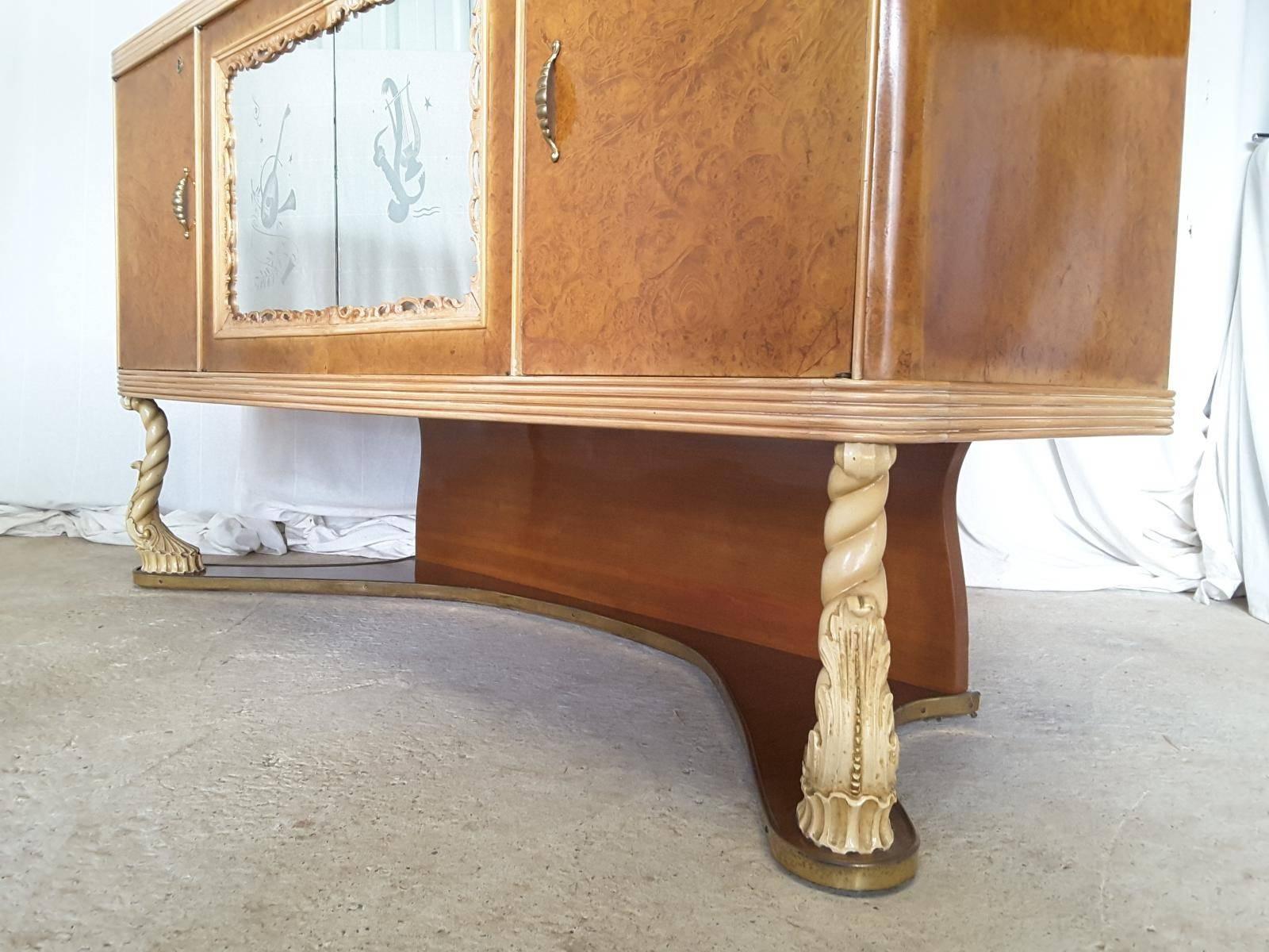An unusual Italian mirror back sideboard designed by Pier Luigi Colli. With etched glass mirror panels to the front doors and detailed mirror back. The case is burl walnut with hand decorated cream legs and moldings.