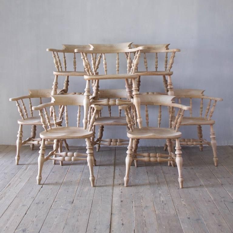 A matching set of eight captain's chairs made in beech and elm, England, circa 1920s.