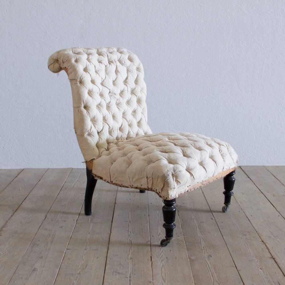 A beautiful buttoned slipper chair with original intact cotton upholstery. Original ebonized decoration and original castors, France, circa 1880. Measures: Seat 56cm wide x 51cm deep.