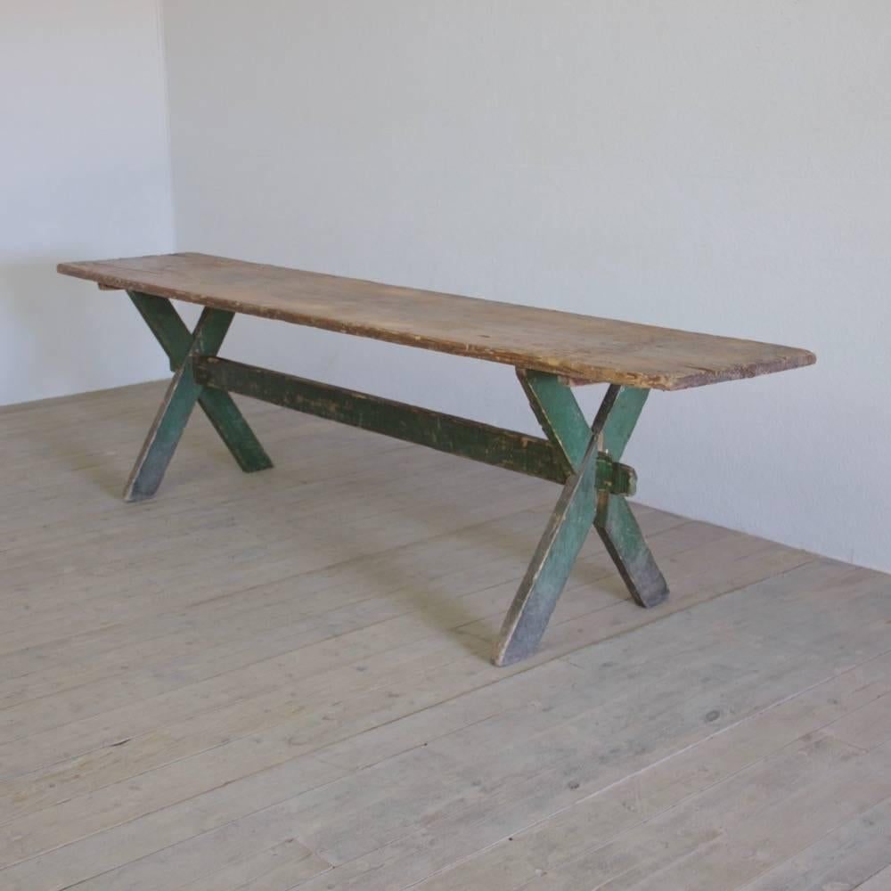 A large Primitive X-frame vendange table, with richly patinated top and original painted base (one leg later), Germany, circa 1900.