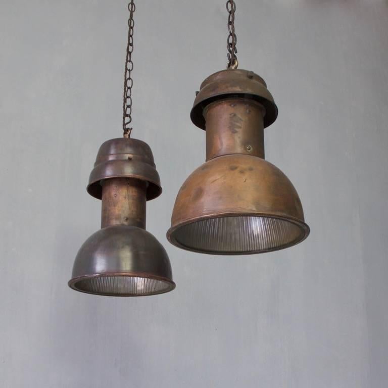 Two unusual and similar copper pendant lights with faceted glass, interiors, England, circa 1930s. Wired and ready to hang. Ceiling roses, chain and hooks may be ordered separately.