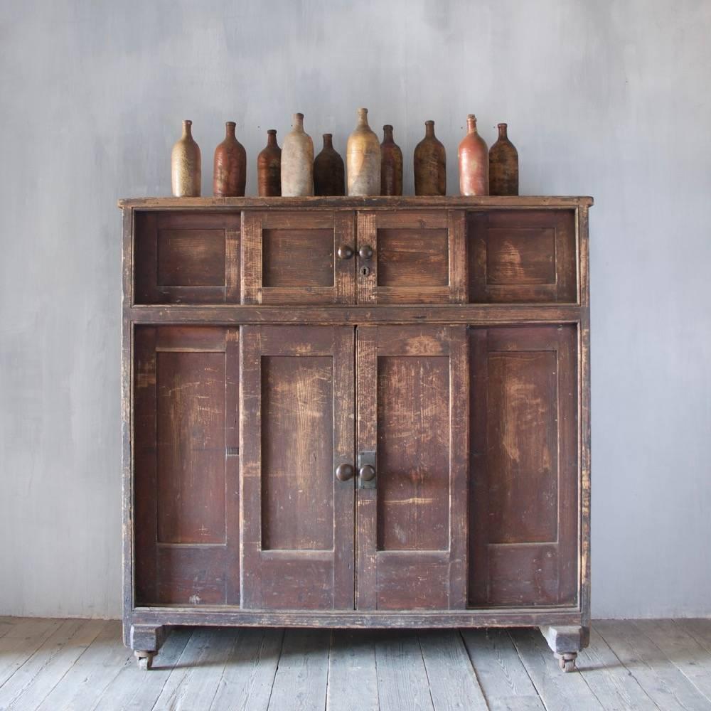 A rare and unusual English 'huffer' or plate-warming cupboard with sliding doors, heavy iron carrying handles and iron castors. Tin-lined and with original finish. England, circa 1880.