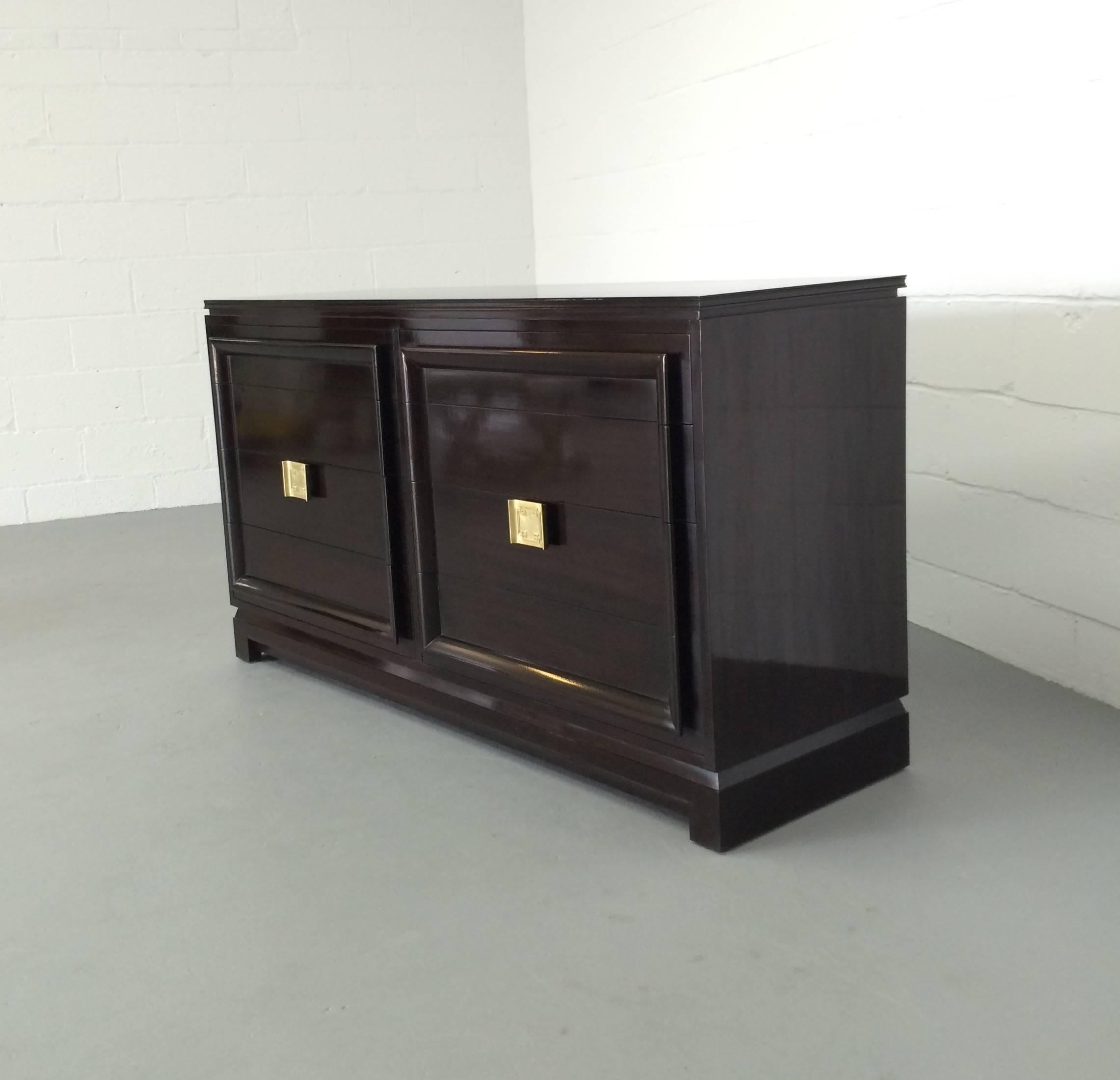 This Asian style, Hollywood Regency dresser or sideboard is absolutely gorgeous! A very dark mahogany with a glossy finish, this dresser is in beautiful condition with Asian inspired hardware on one drawer.

There are eight drawers and all but one