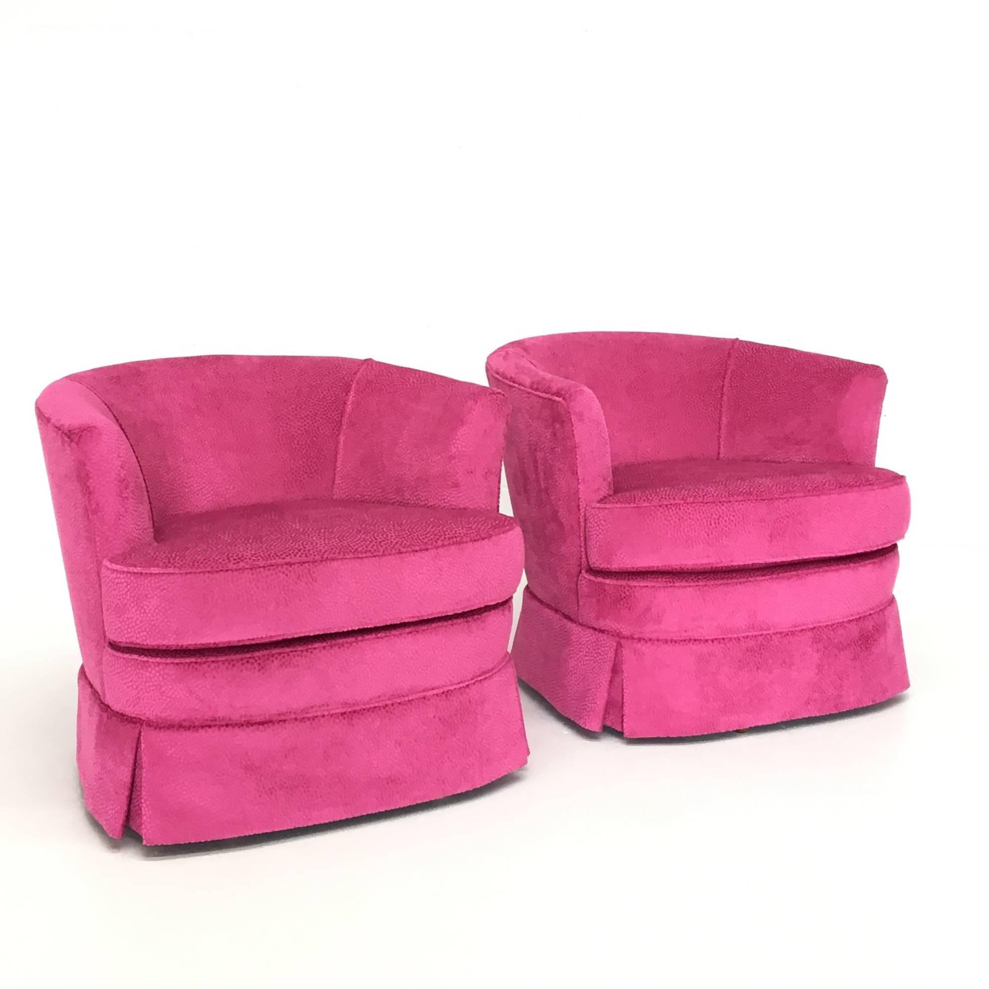 A wonderful pair of Mid-Century Modern swivel club chairs, swivelling 36 degrees with no memory. Newly upholstered with all new foam/Dacron in a pink, polka dot textured velvet. A lovely modest size wouldn't overwhelm any room.