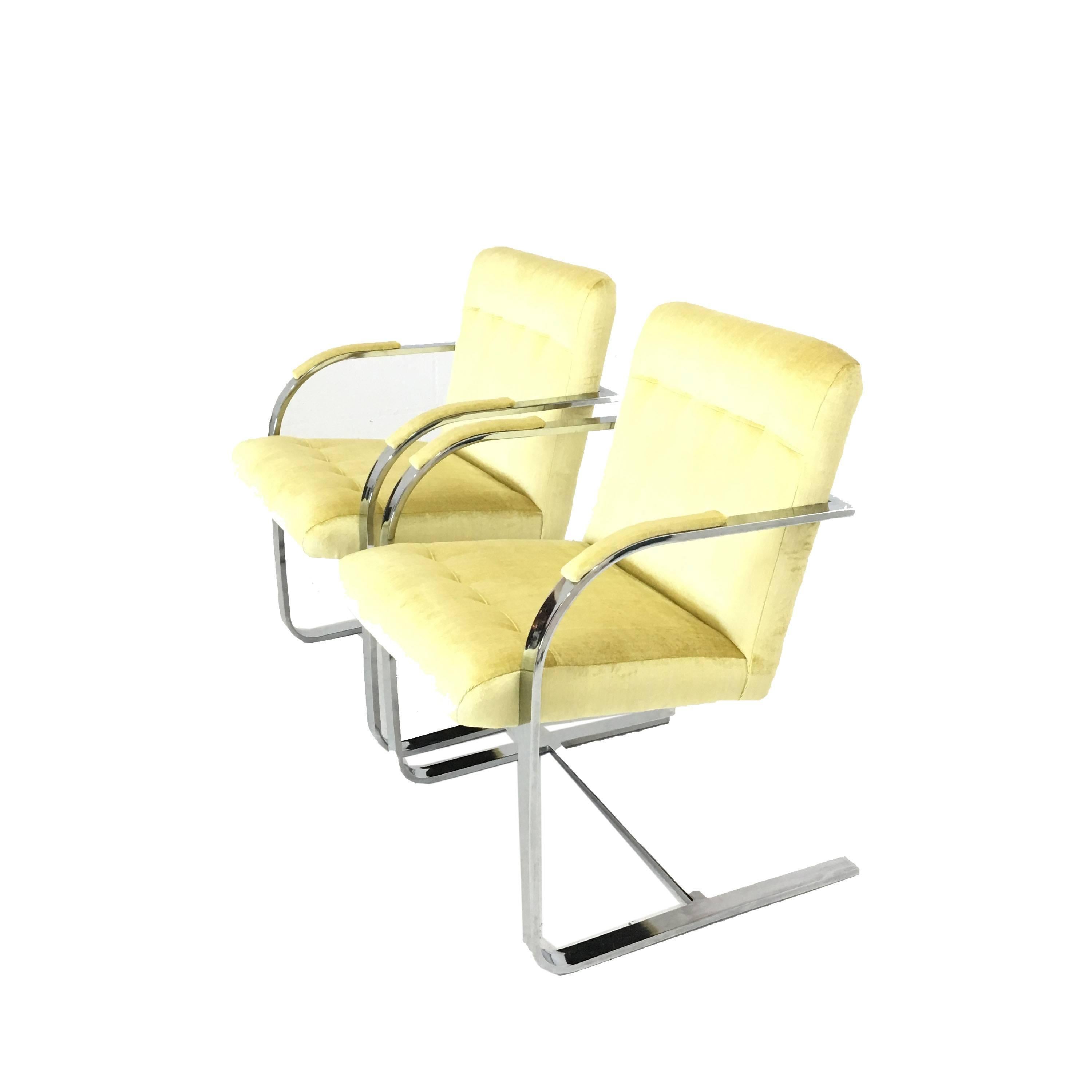 A pair of Mid-Century Modern Chrome framed occasional chairs newly upholstered in a striated yellow velvet. Arms each have a velvet pad for comfort and chairs have a slight rock backwards and forwards. Super comfortable! Price is per item. Age