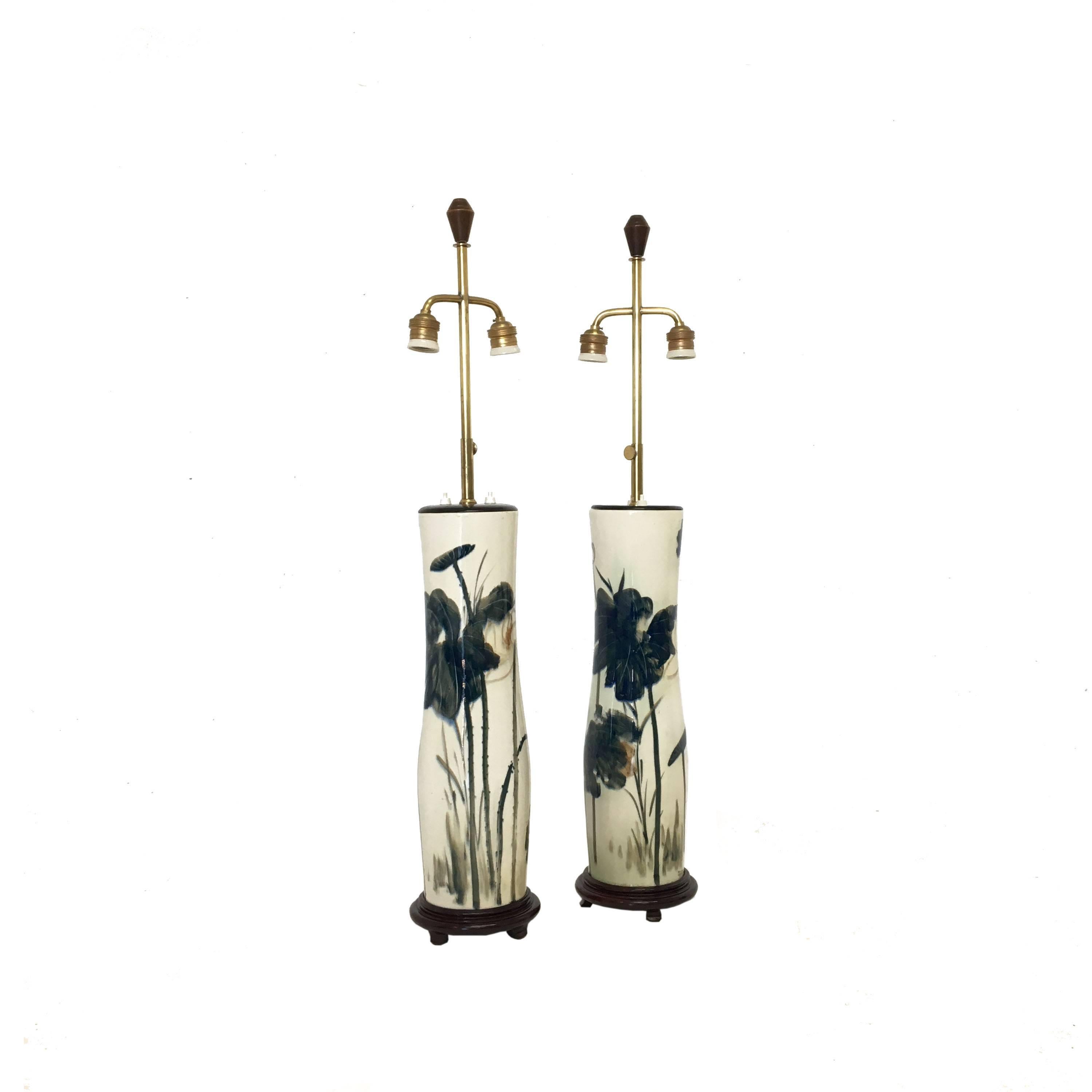 Pair of French Chinoiserie style hand-painted porcelain lamps. Chinoiserie botanical scene. Wonderfully decorated. The whole supported on a round wooden base. Shades included.
Age appropriate wear. One lamp has a hairline crack as depicted in