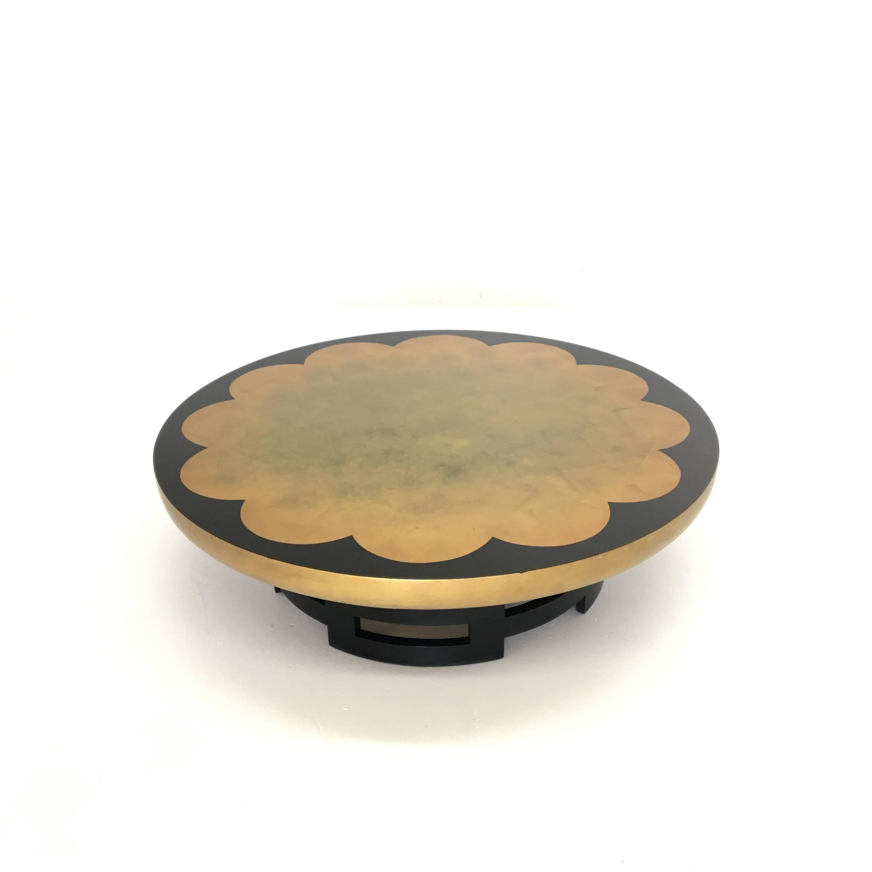 Mid-Century Modern Asian inspired lotus coffee table in the gold leaf finish designed by Theodore Muller and Isabel Barringer for Kittinger. This comes with a circular glass which covers the top surface protecting the finish. Age appropriate wear.