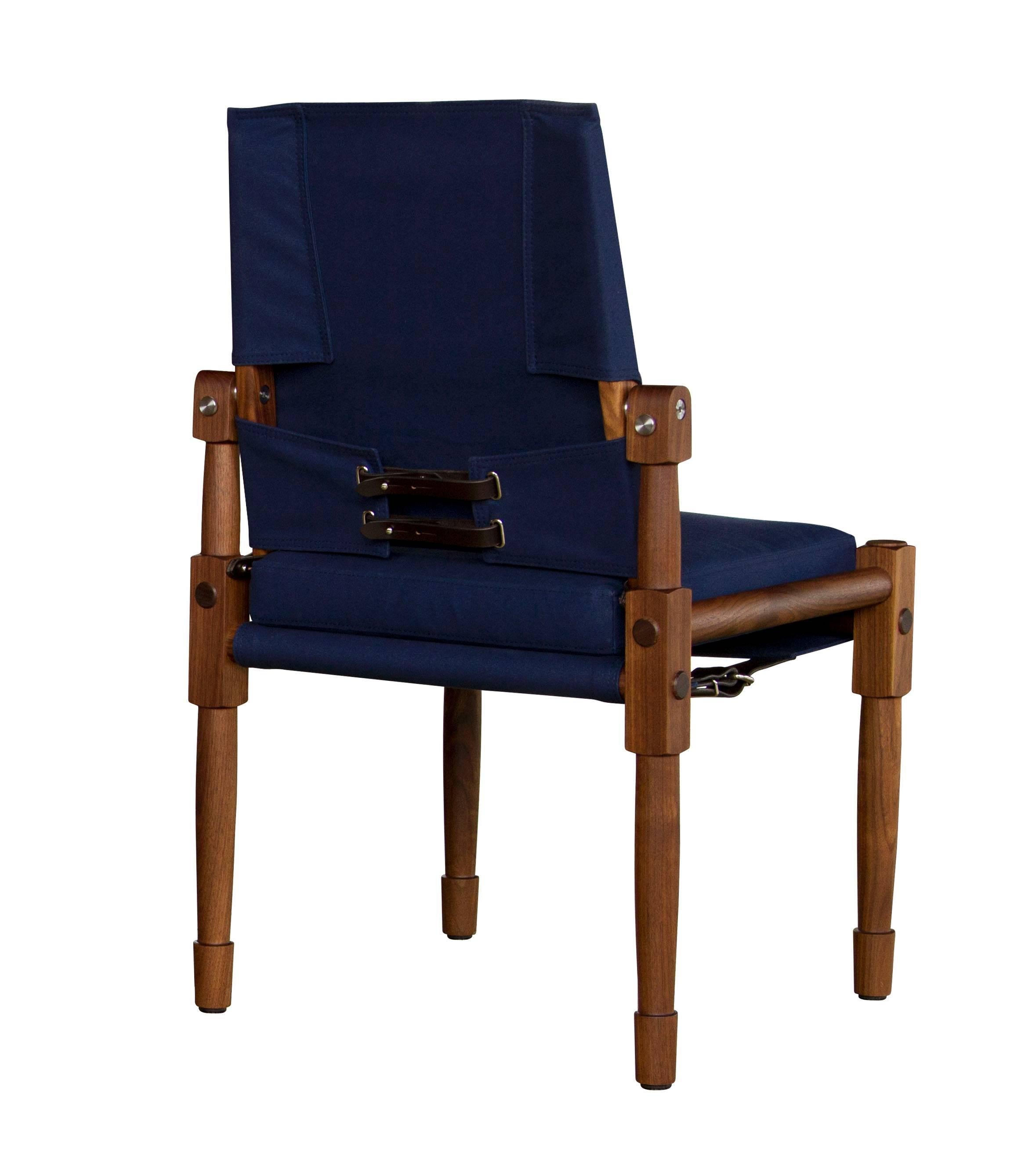 A Chatwin 02 dining chair in oiled walnut with navy canvas upholstery and dark chocolate English bridle leather strapping.

The modern campaign collection by Richard Wrightman combines the vernacular of traditional form with a modern aesthetic,