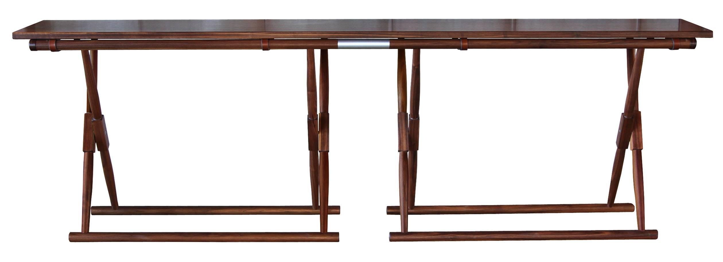 The Matthiessen console in oiled walnut with multiple dark chocolate English bridle leather straps that wrap around each bottom length of the console and buckle underneath for a handsome underside detail.

The modern campaign collection by Richard
