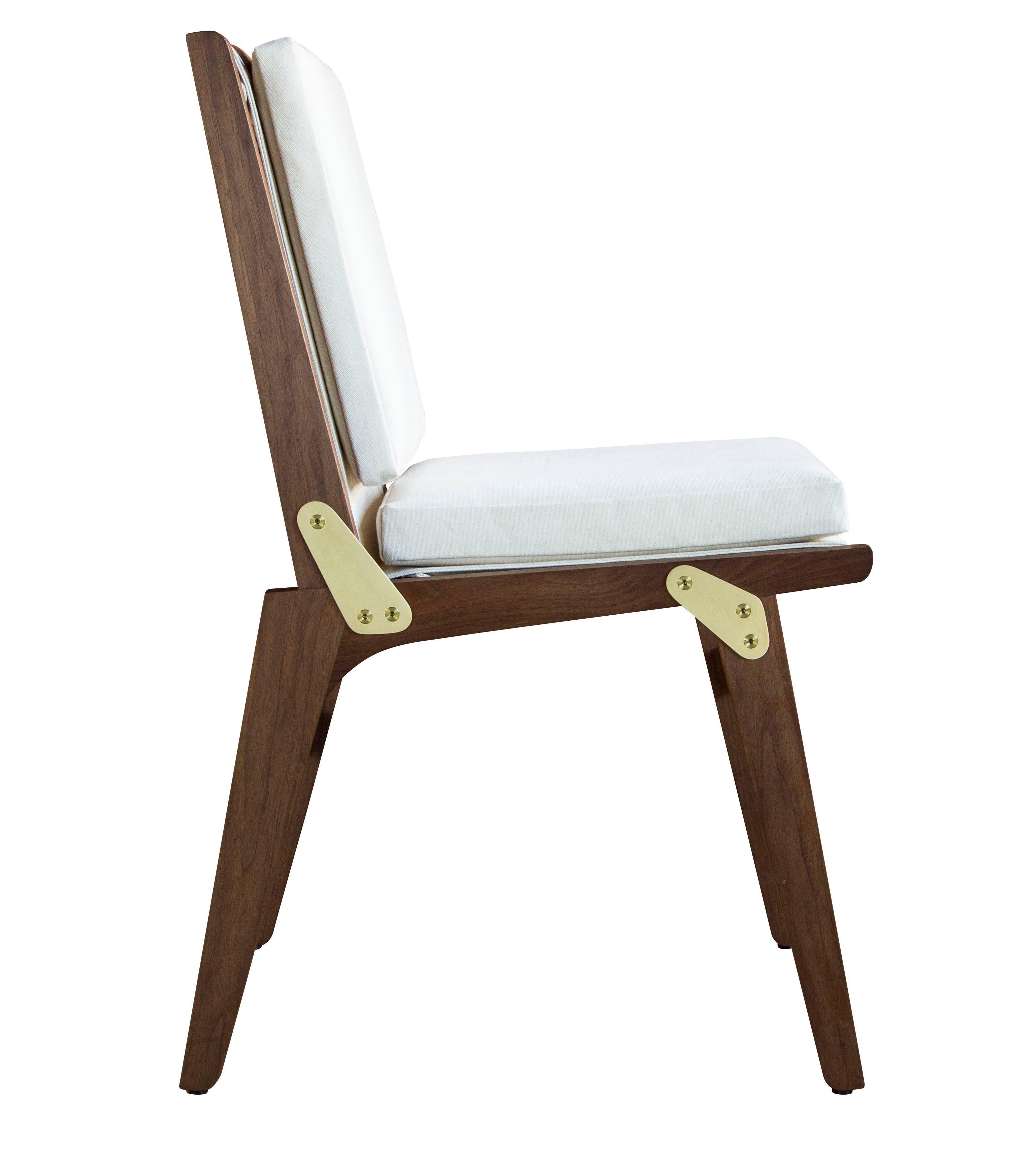 The Officer's Field Set dining chair (non-folding version) in oiled walnut with white canvas upholstery and coach English bridle leather strapping.

The modern campaign collection by Richard Wrightman combines the vernacular of traditional form with