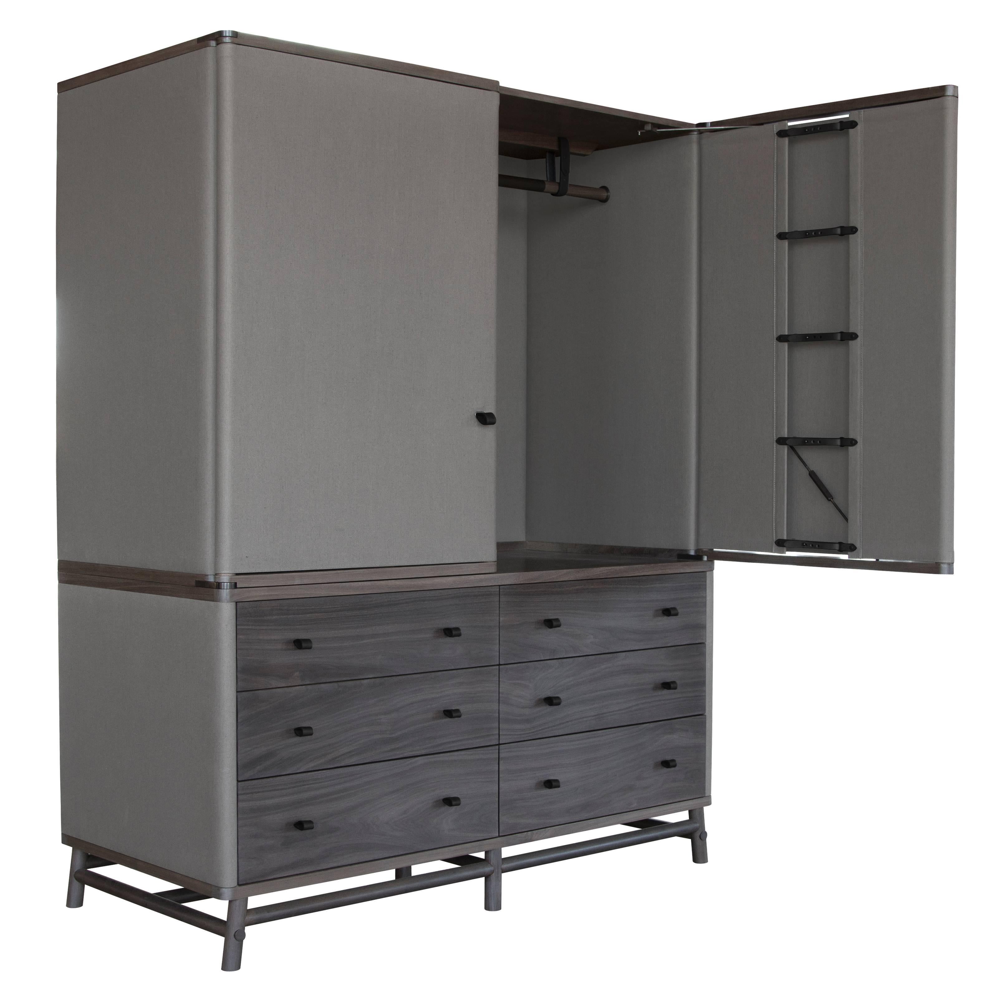 The Lambert armoire in silver grey walnut, Limonta Canvas No. 8 with Moore & Giles: Valhalla / Graphite leather strapping. 
Drawers constructed with under-mounted soft drawer glides.

The modern campaign collection by Richard Wrightman combines the