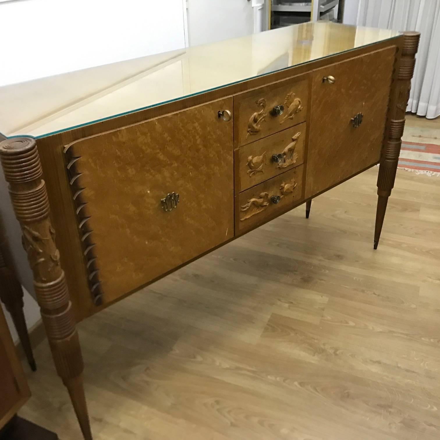 Italian 1950s sideboard in light carved wood, original handles, hand-carved animals on the sides and on the drawers, glass at the top, designer Pier Luigi Colli for Marelli Cantù