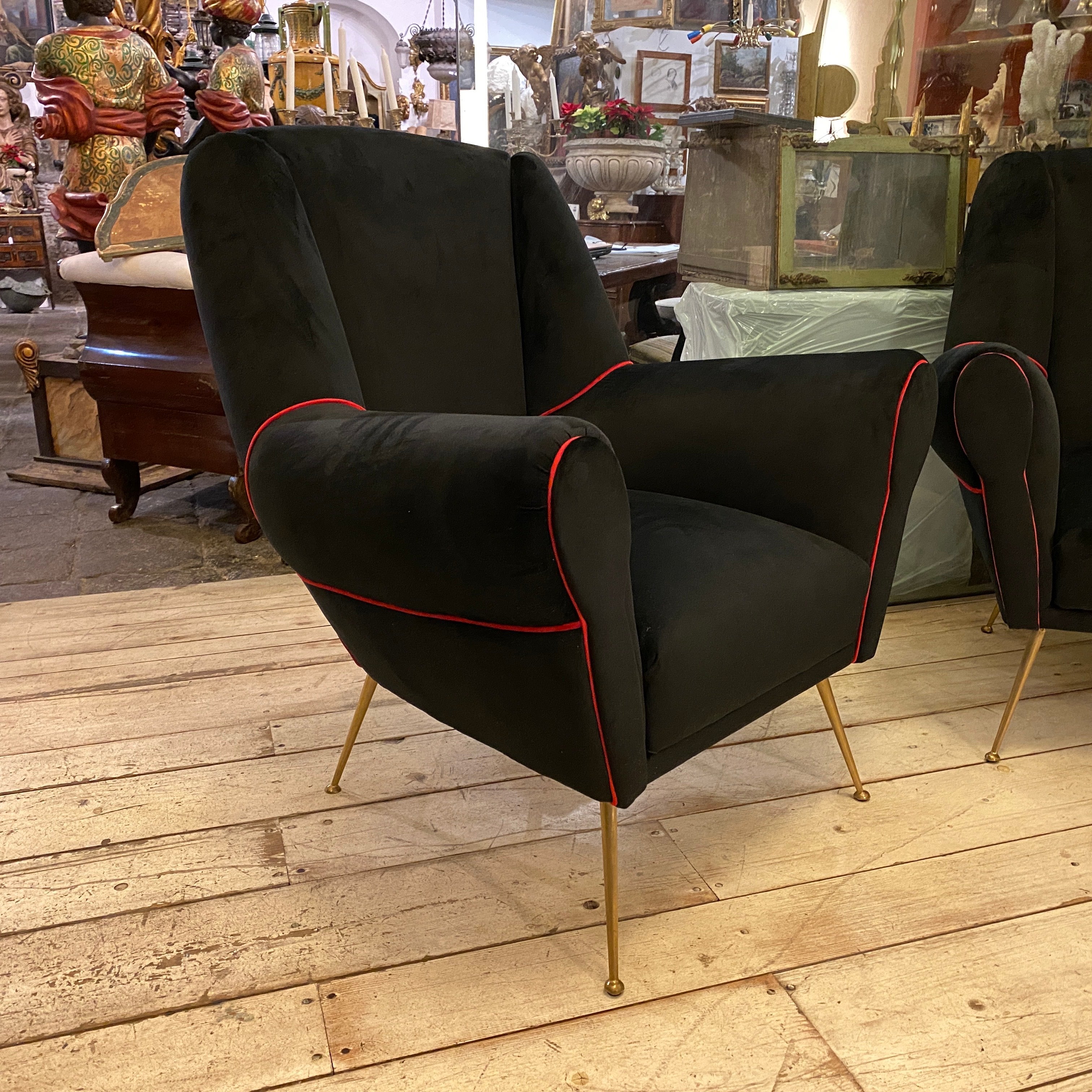Two upholstered Mid-Century Modern armchairs designed and manufactured in Italy in the 1950s in the style of Giò Ponti, black velvet has red finiture, brass it's in original patina.