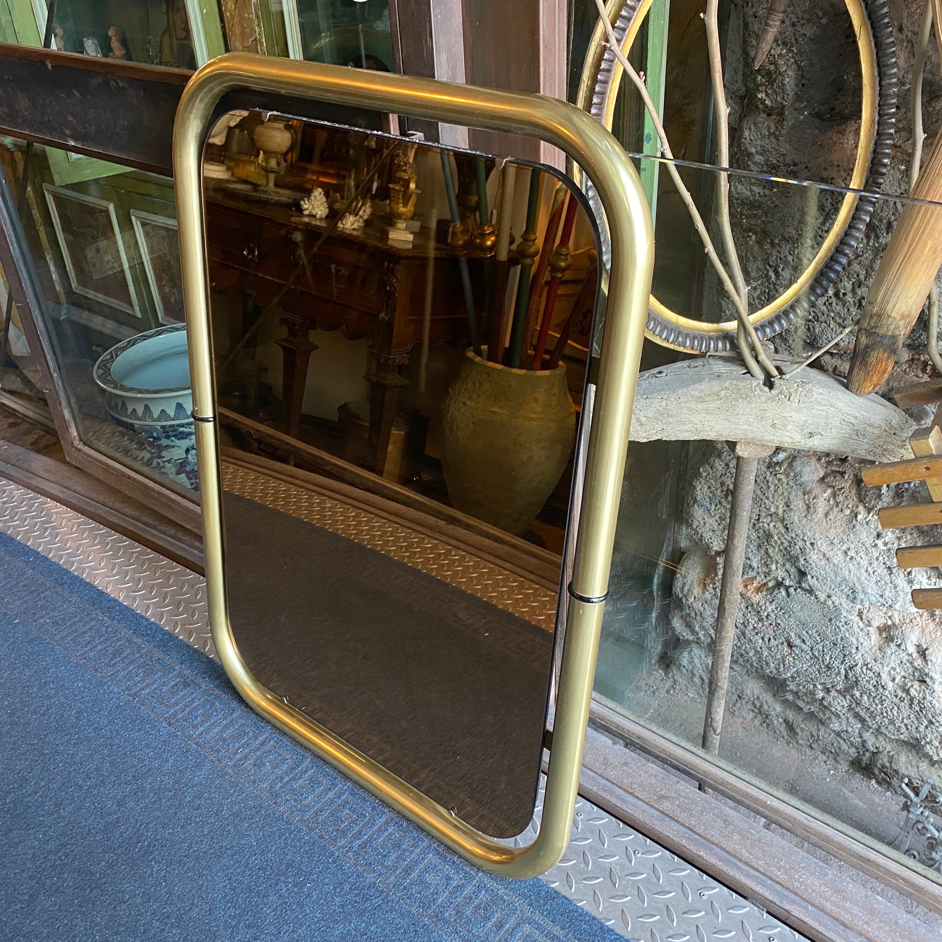 An high quality solid brass and pink glass wall mirror designed and manufactured in Italy in the Seventies by Cristal Arte. Brass it's in original patina, mirrored glass it's in perfect conditions. It's a super example of italian space age