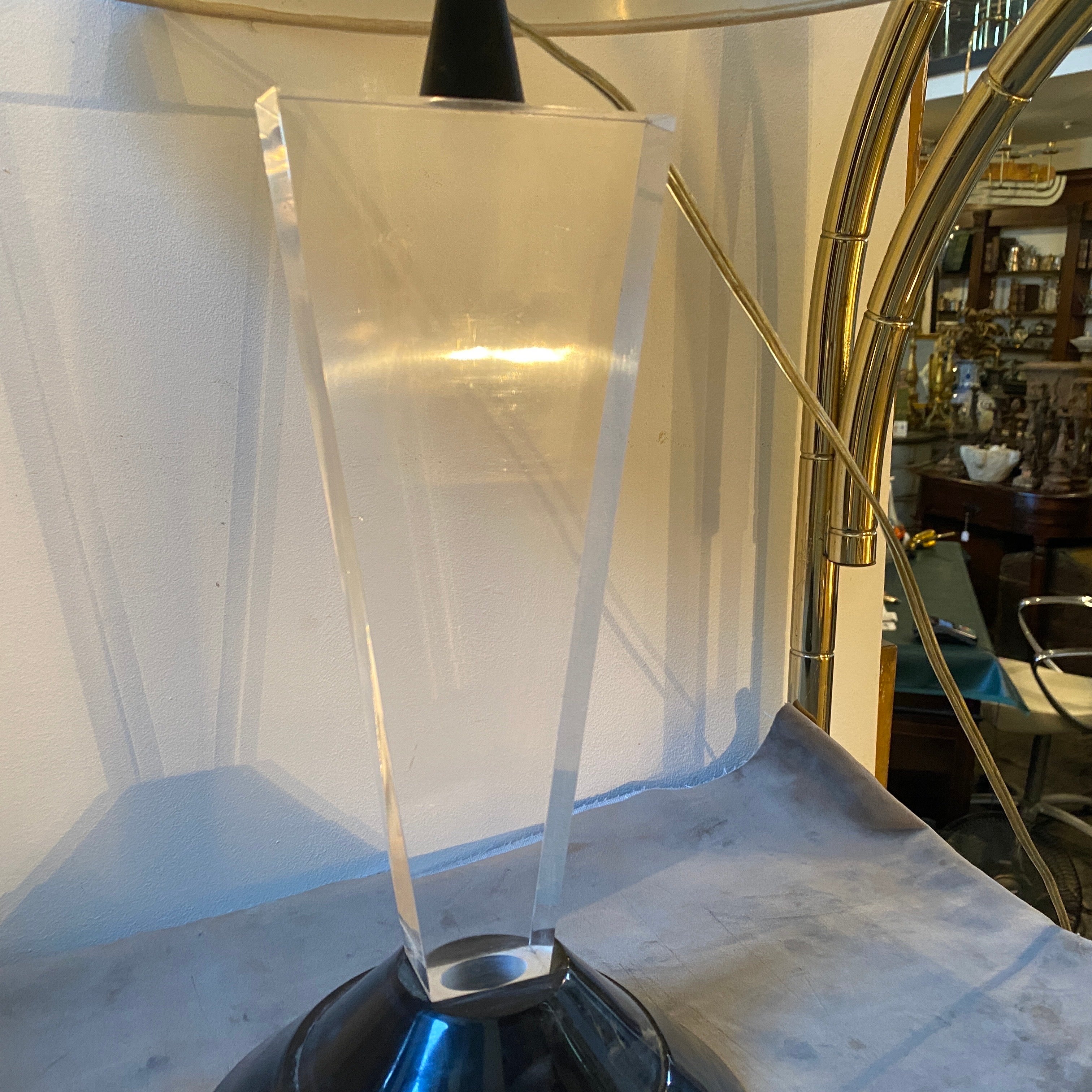 A black and transparent Lucite table lamp designed and manufactured in Italy in the Eighties in the style of Memphis Milano, the base of the lamp is 44 cm in height. It works both 110-240 volts and it needs a regular e27 bulb.
The lamp exemplifies