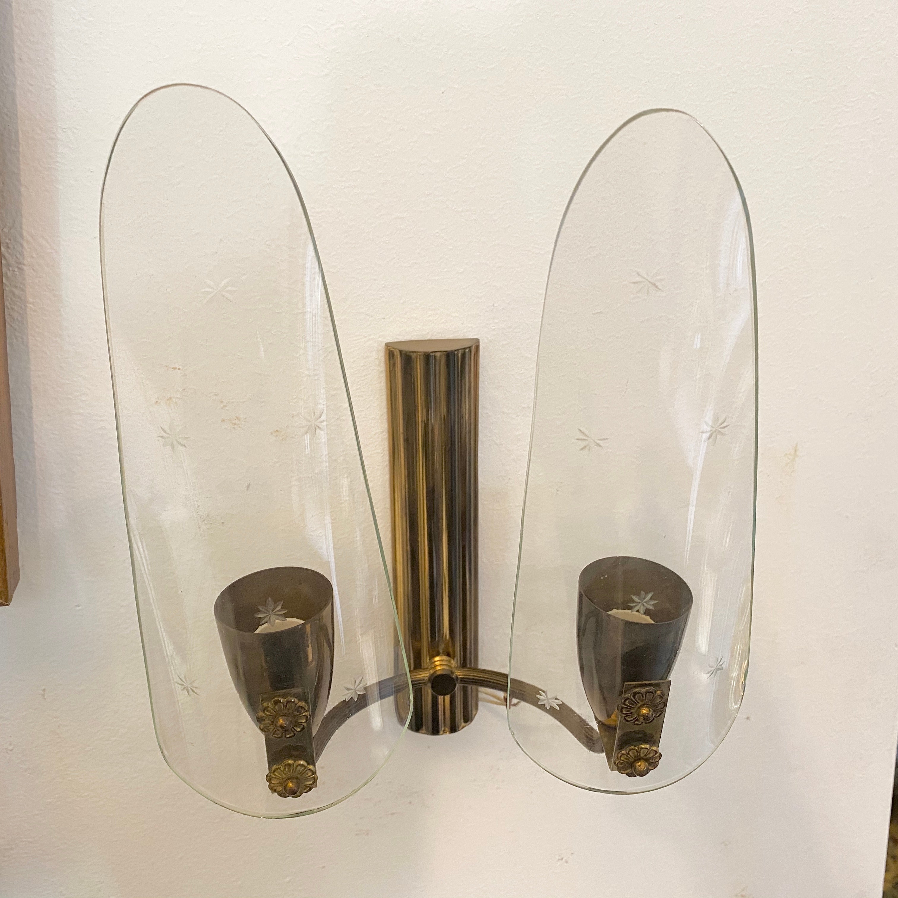 Particular two-light wall sconces in the manner of Pietro Chiesa, brass it's in original patina, glasses are hand engraved and in perfect conditions. They work 110-240 volts and need two regular e14 bulbs. Three sconces available, price is for one
