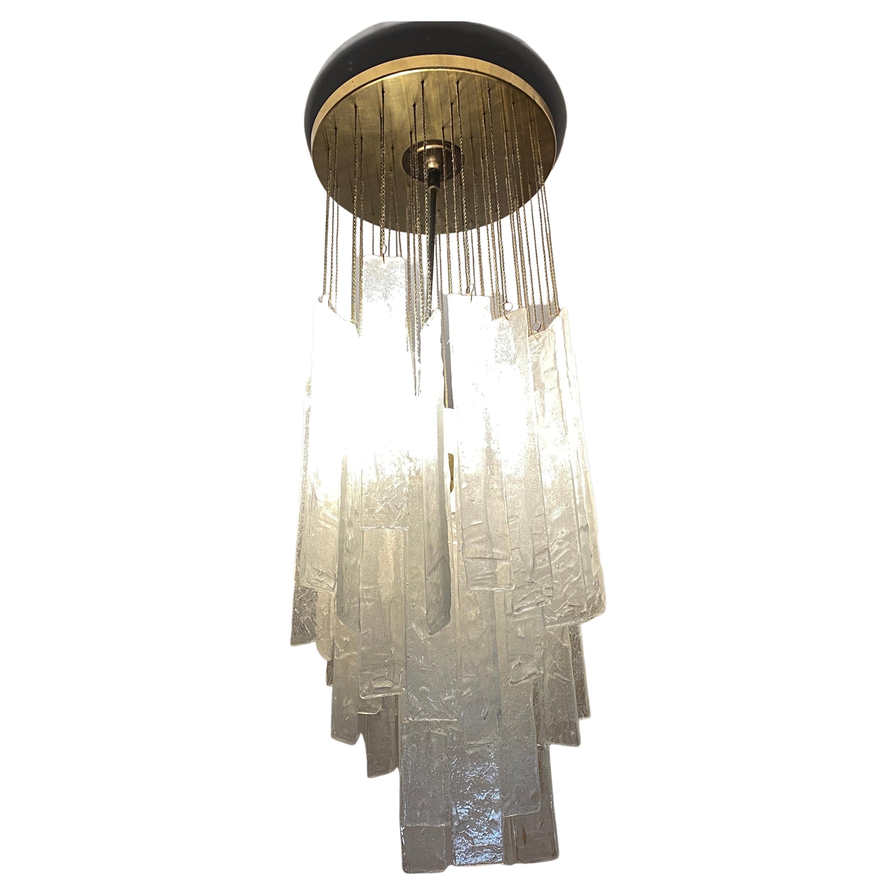 An amazing Mid-Century Modern murano glass and brass chandelier made in the Seventies by italian famous manufacturer AV Mazzega, brass it's in original patina, white and transparent glasses are in perfect conditions, it works 110-240 volts and need