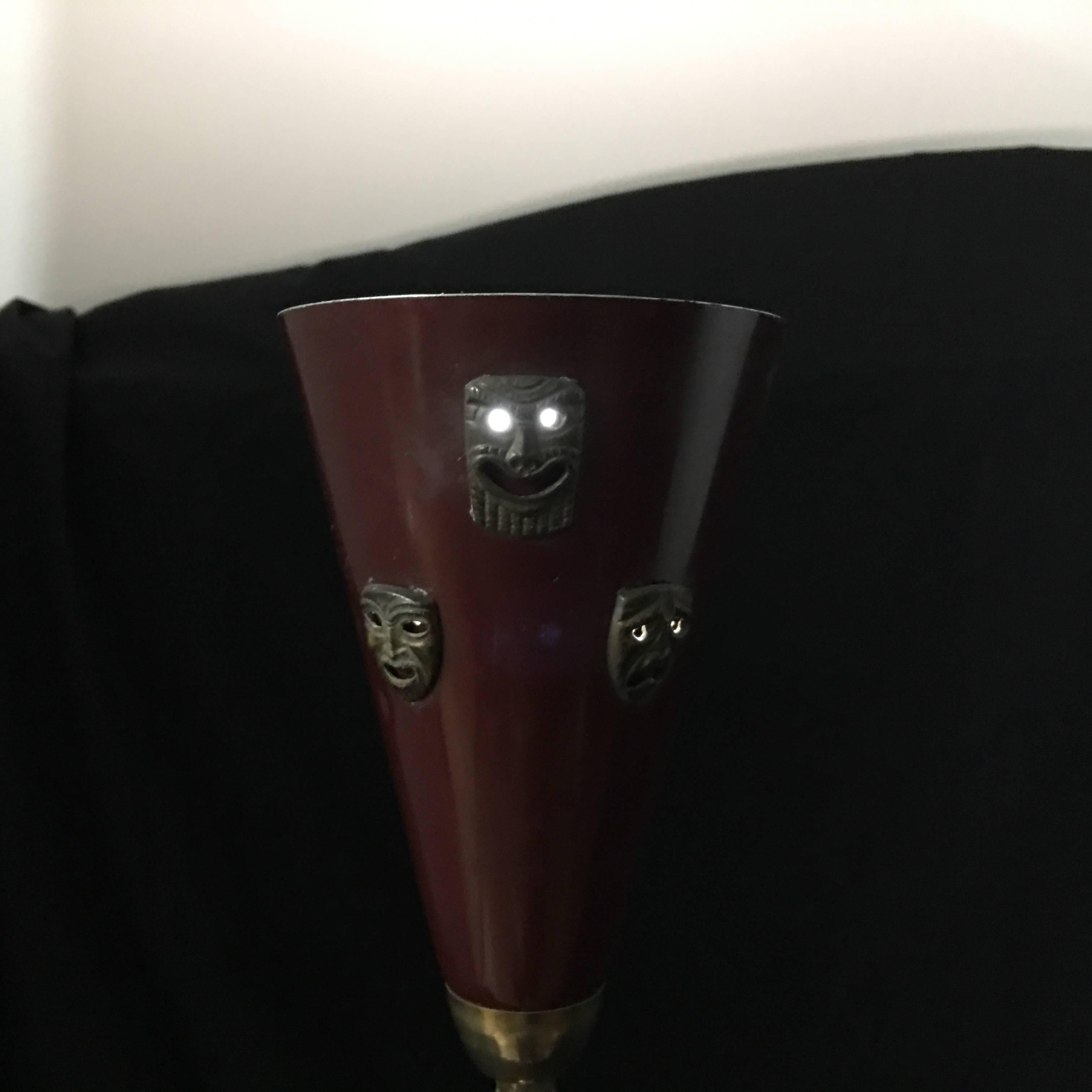 Rare Italian table lamp, brass base, red painted cone on the top with three theatre mask in bronze, in perfect working order.