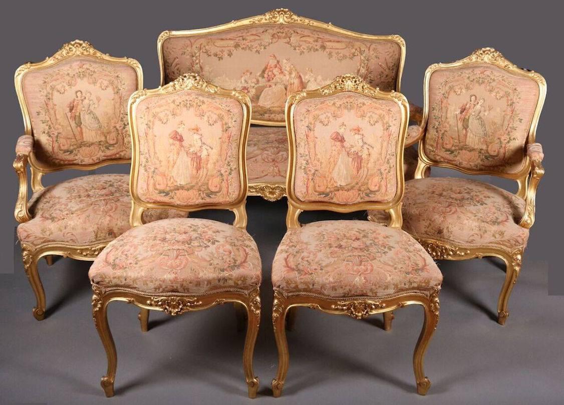 French Louis XIV parlour set includes settee, two fauteuils (armchairs) and two side chairs featuring Classic gold gilt framing, molded cartouche-shaped seat backs, cabriole legs, and original scenic and floral tapestry upholstery depicting