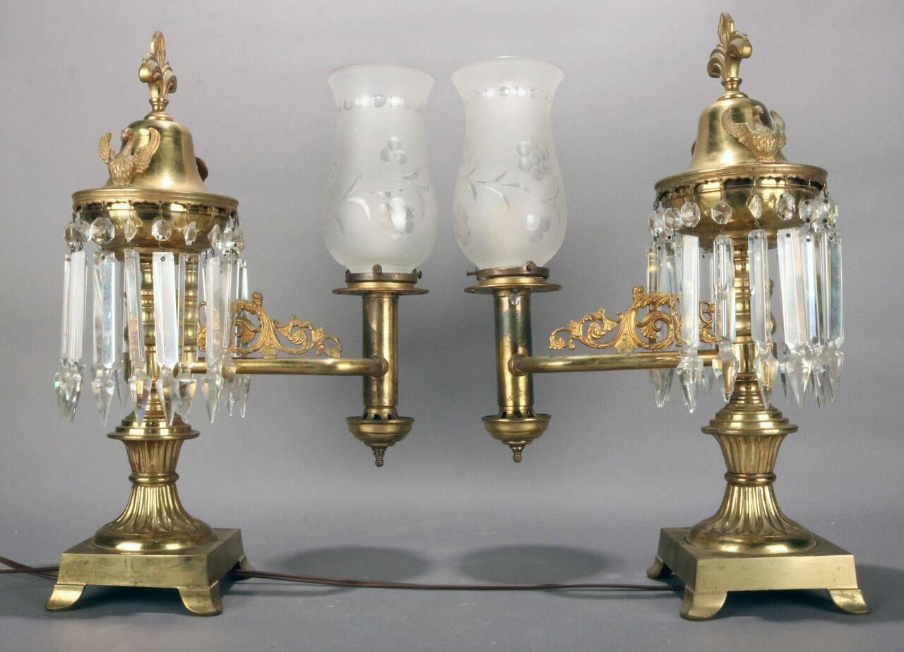 19th century pair bronze astral electrified dragon (solar or sinumbra) lamps feature curved arms, opposing falcon mounts, cut crystal prisms, and later replacement frosted shades, circa 1840.