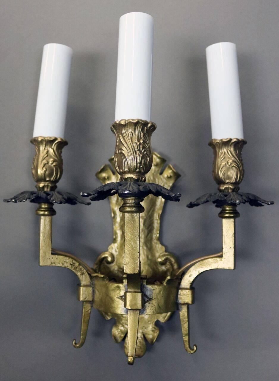 Pair of antique Arts & Crafts Gothic style brass three-arm wall sconces, circa 1900.