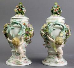Antique Pair of Meissen Polychrome Figural and Floral Lidded Urns with Cherubs