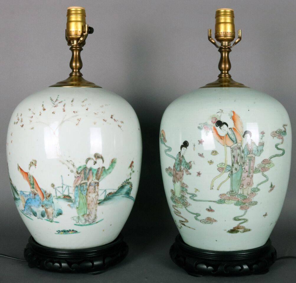 Antique pair of Chinese porcelain lamps feature hand enameled scene with dancing women and chop marks atop carved rosewood footed base, circa 1920.

Measures: 10" W x 18" H without shade.