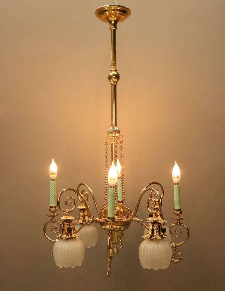 Antique Victorian brass electrified combination chandelier (originally gas and electric) features eight scrolled arms with four candle lights and four drop lights with frosted shades (up and down chandelier), newly re-wired, late 1800s.
