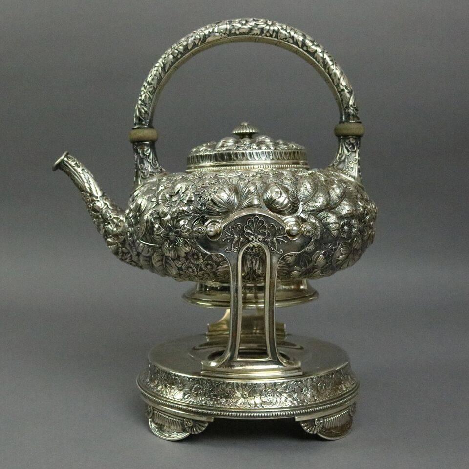 Rare seven-piece antique Gorham repousse sterling silver coffee and tea serving set in pattern #1333 features intricate all-over floral pattern accented with beaded rimming and accent elements of scallops Nautilus shells and reeding. Set includes: