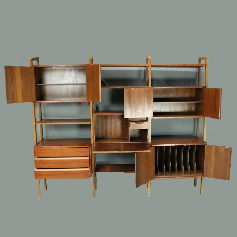 Mid-Century Danish modern walnut wall unit includes fall front desk, two storage cabinets, record cabinet, shelving, and three drawers, circa 1960.

Measures: 73.5" H x 86.5" W x 16.5" D.