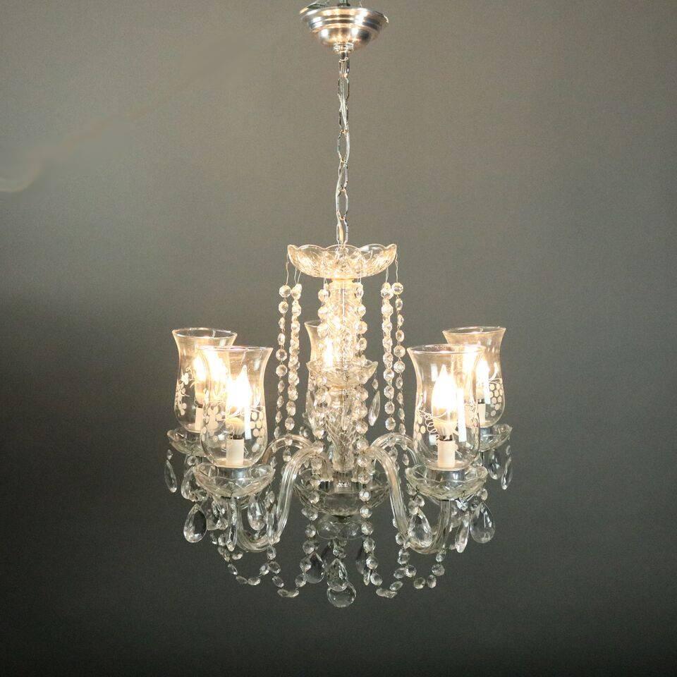 Vintage French style chandelier features cut crystal shaft seated on chrome base with five crystal arms terminating in etched shades with grape motif, all decorated with strung and drop cut crystals, newly re-wired, circa 1950

Measures: 33