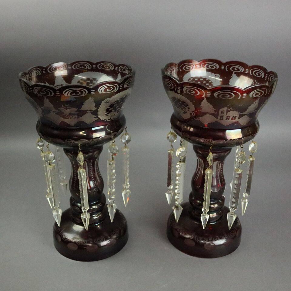 Antique pair ruby Bohemian glass cut to clear mantel lusters feature countryside scene including deer, birds, and a cottage, surrounded by hanging cut crystal prisms, circa 1890

Measures: 12.75" height x 7"diameter.
