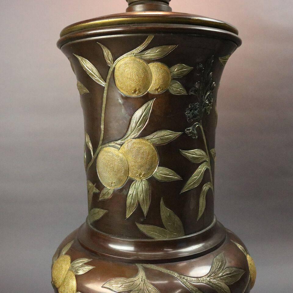 Antique Aesthetic Movement embossed and gilded table lamp features fruit and leaf motif and sits atop scrolled tri-foot base, newly re-wired, circa 1870.

Measures: 33" H x 11" diameter, 4" fitter.