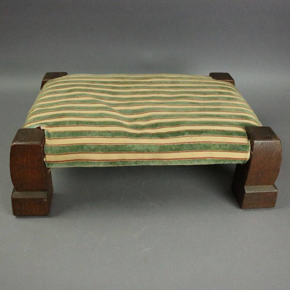 Early antique Gustav Stickley Mission oak upholstered gout footstool features traditional Arts and Crafts design of simplicity and functionality, branded Gustav Stickley mark on frame, more recent upholstery, circa 1905.

Measures: 5