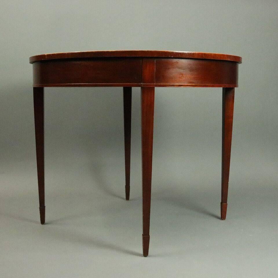 Vintage Baker round centre table features sunburst top with twelve inlaid and banded flame mahogany sections surrounding a central medallion seated atop four tapered legs, Baker Furniture tags below, circa 1950

Measures: 29.5" H x 36"