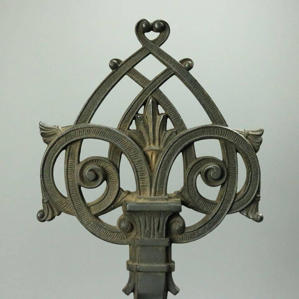 Antique pair Oscar Bach School wrought iron andirons feature Gothic Aesthetic design with angular bases rising from paw feet to opposing gryphon heads below twisted shafts terminating in a stylized Triquetra finial (Symbol of Eternal Spiritual