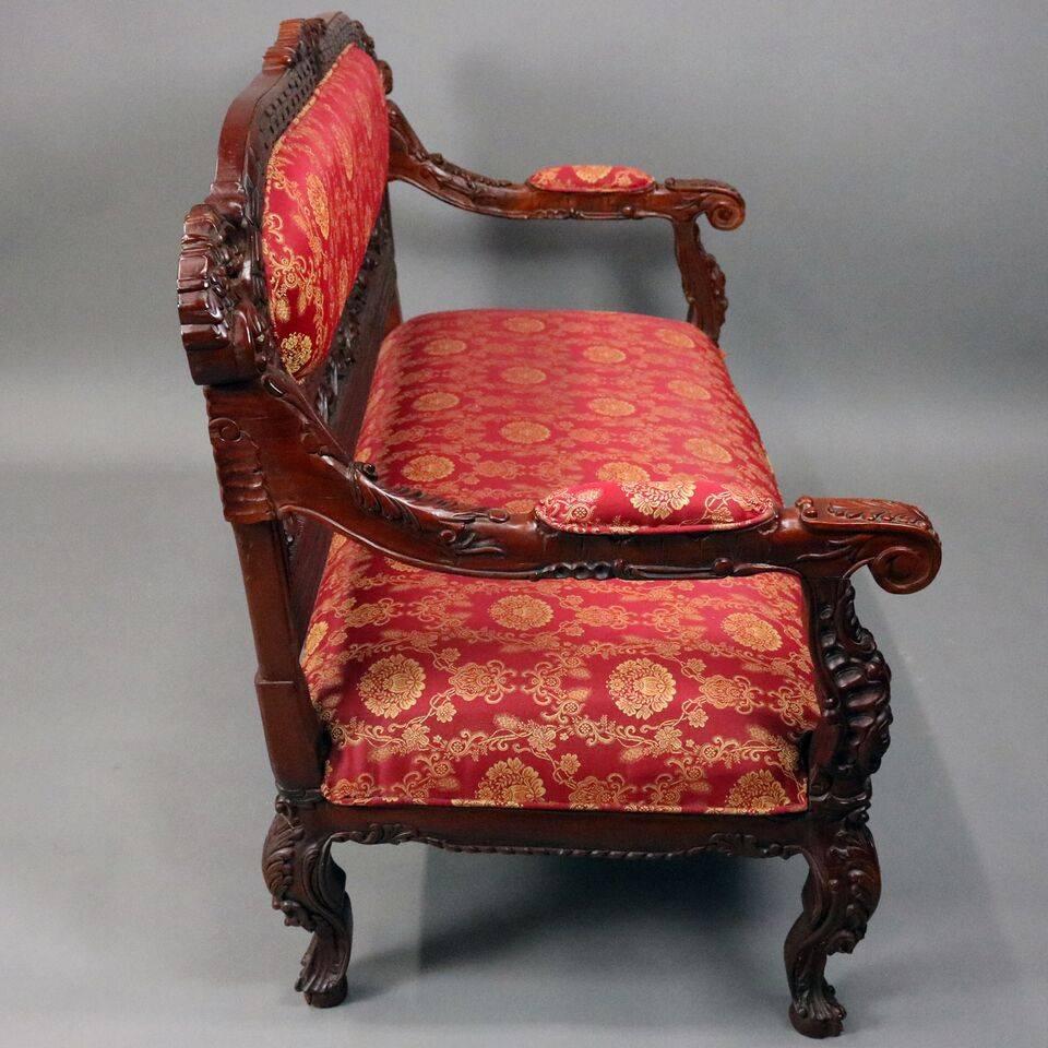 Vintage Karpen School Baroque style settee feature heavily carved frame mahogany, pierced back including foliate, volute, and acanthus leaves with central upholstered medallion, covered scrolled arms, upholstered seat supported by cabriole legs with