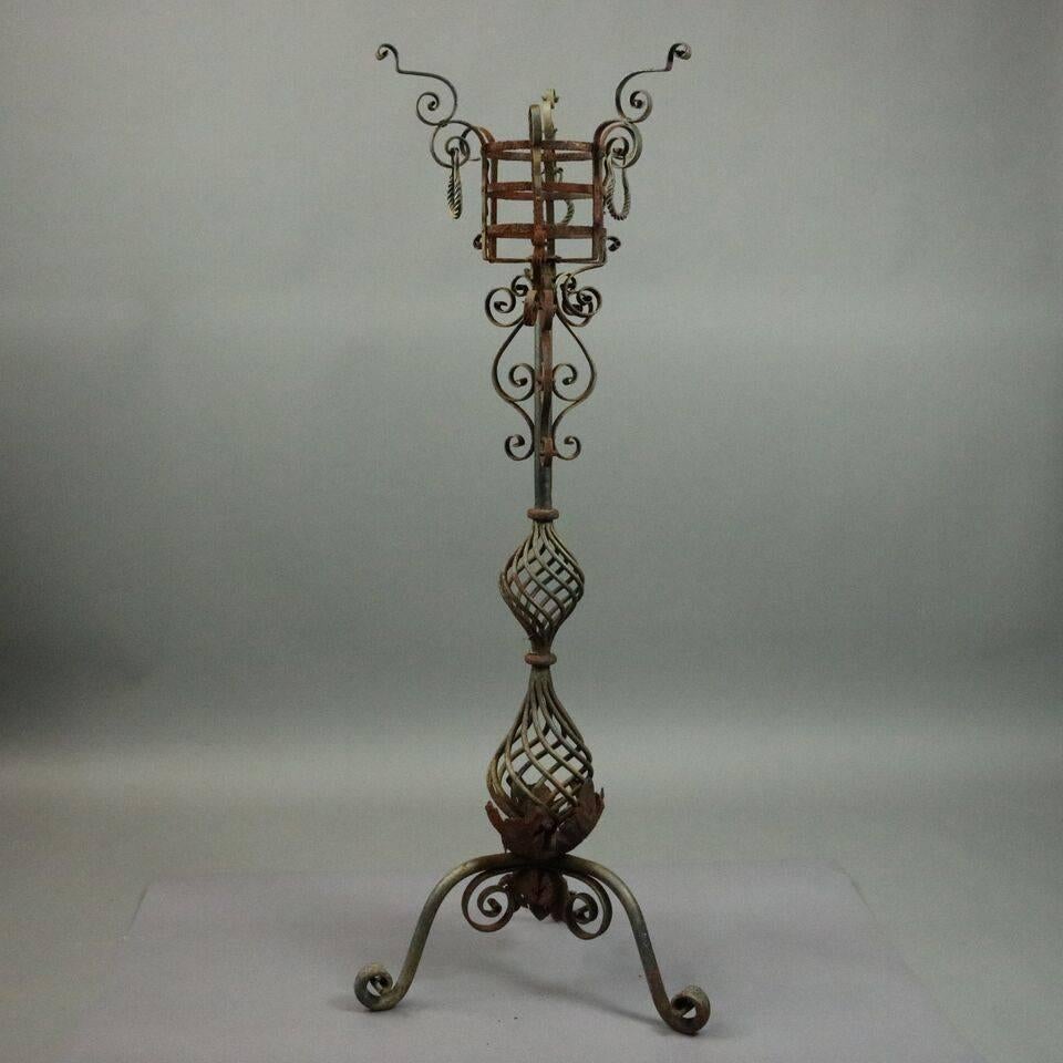 Antique Arts & Crafts Yellin School wrought iron plant Stand features scrolled and foliate design throughout, twisted iron hour-glass base seated atop tri-pod of scrolled legs and feet, circa 1910.

Measures: 58" height x 7" diameter.