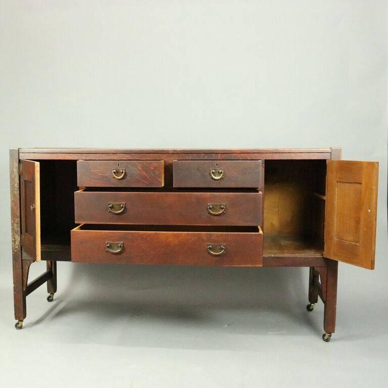 Antique Arts & Crafts Stickley Brothers Mission oak sideboard features two small over two long drawers flanked by two blind interior storage compartments, bronze hardware, stamped "Stickley Bros. Grand Rapids", circa 1910.

Measures: