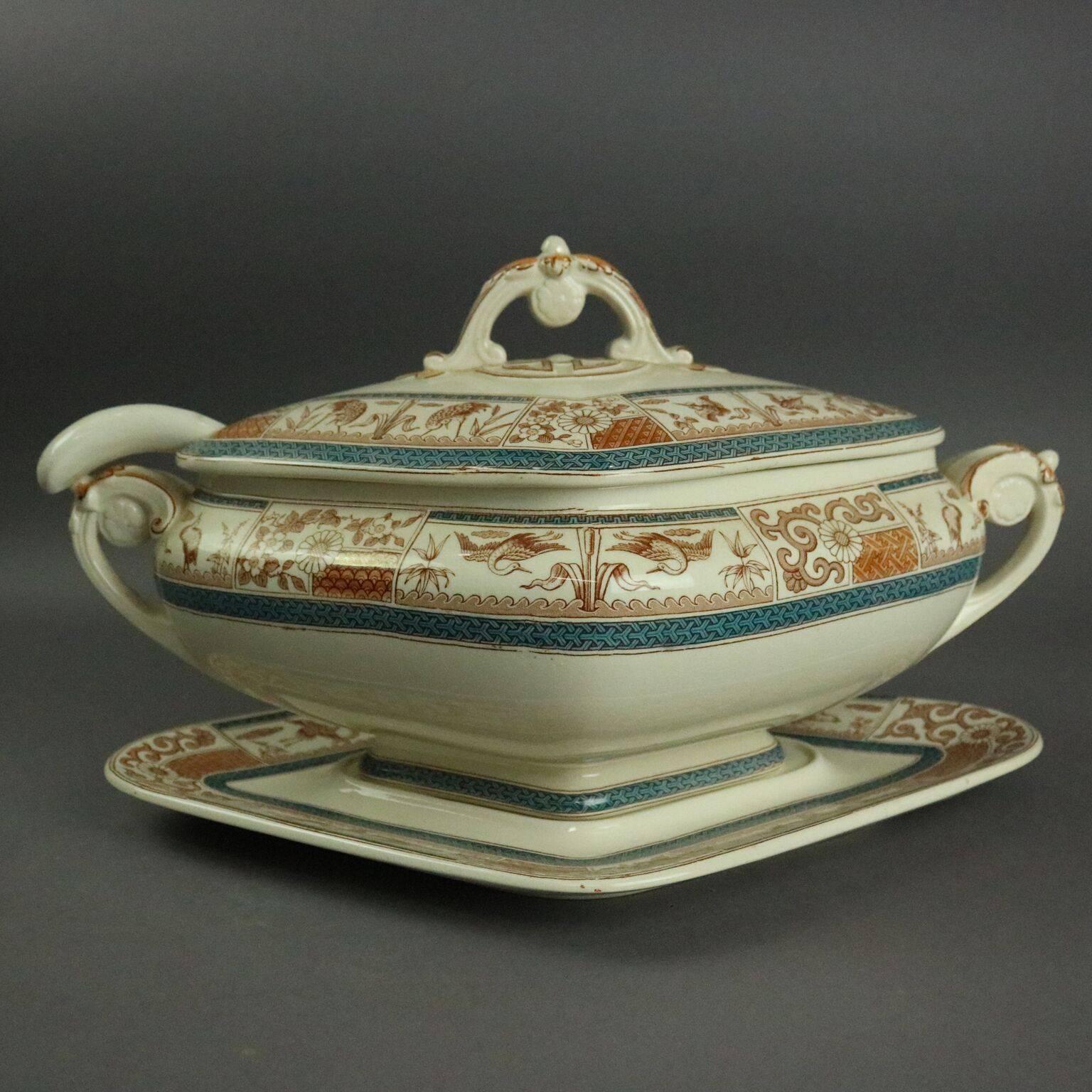 Antique Aesthetic Movement English Staffordshire transferware porcelain lidded tureen features diamond shape, banded foliate design and includes under tray and ladle, circa 1870.

Measures: 9" H X 16" W X 11" D.