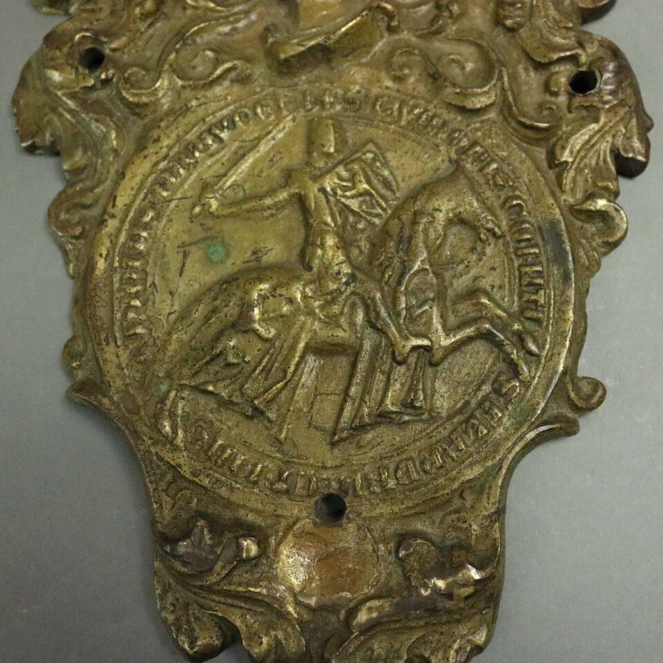 Antique French Masonic Knights Templar cast bronze door knocker features scrolled and foliate plate with central medallion of knight on horseback, figural arm and Hammer knocker, circa 1900

Measures: 8" H x 6" W.