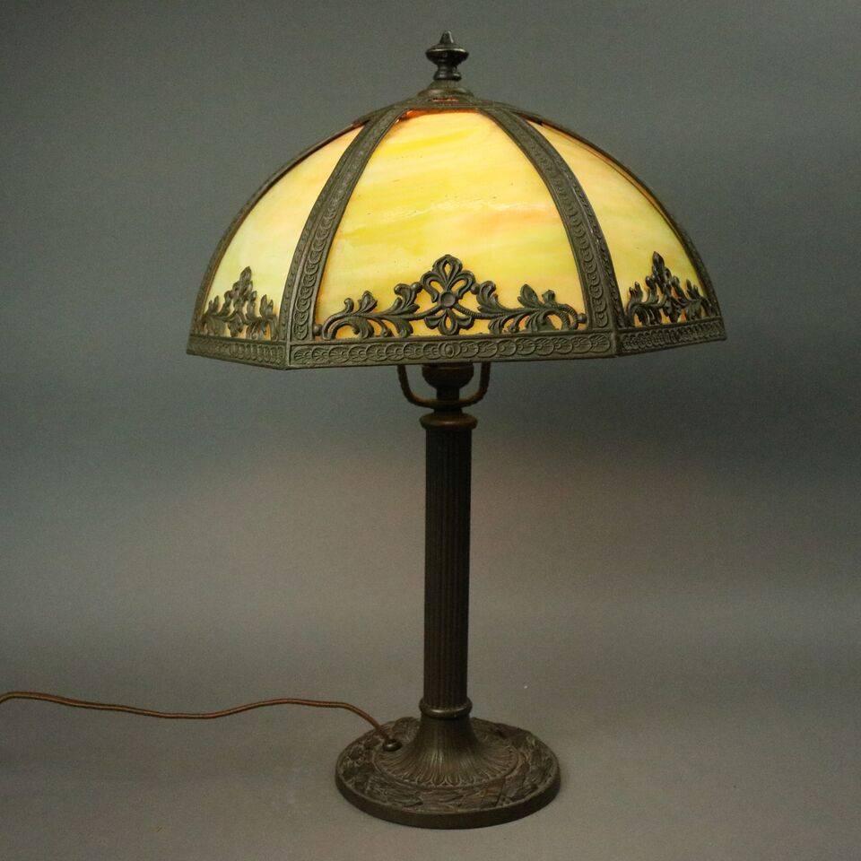 Antique Arts and Crafts table lamp by Miller & Co. features six panel foliate filigree slag glass shade, signed cast bronze base, original wiring, circa 1920

Measures: 21