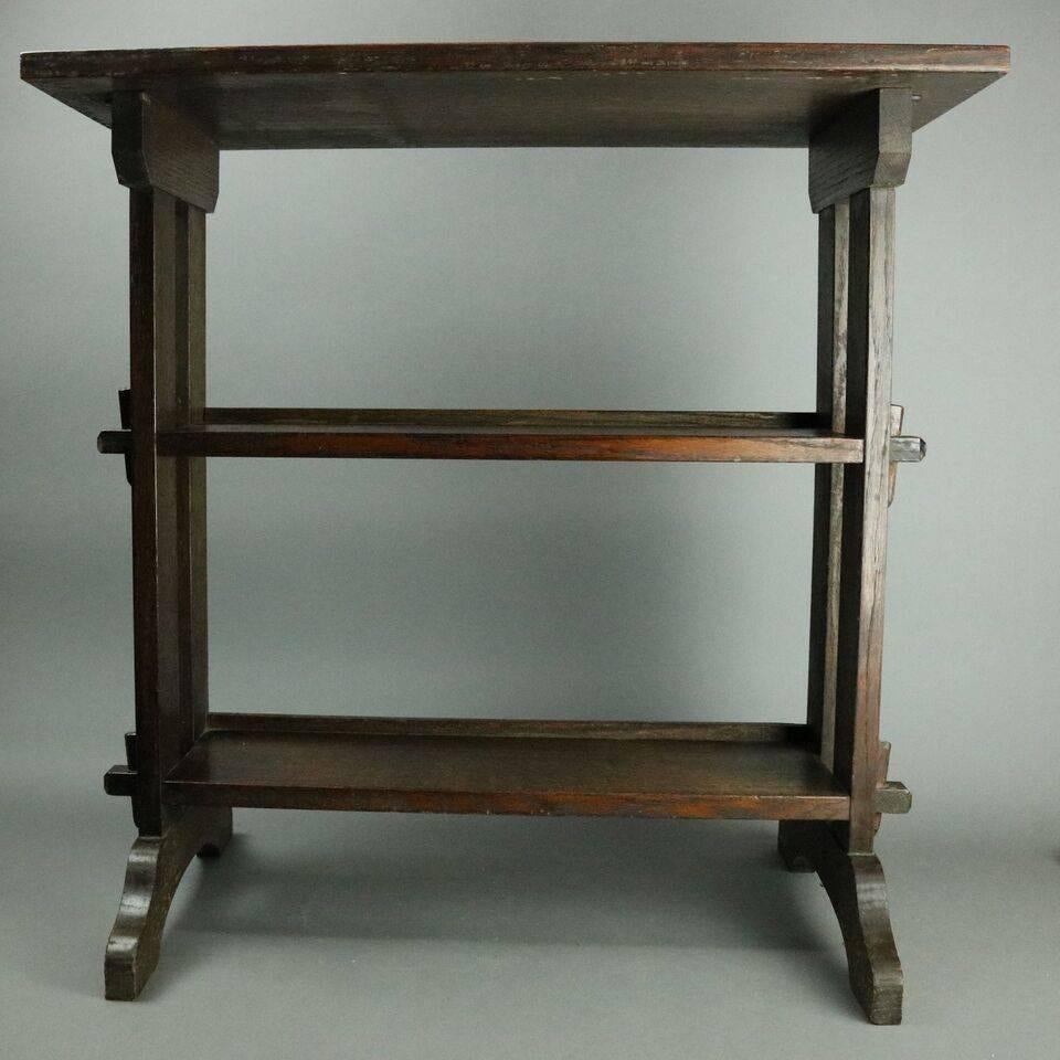 Roycroft Oak Little Journey book stand features two lower shelves and keyed through-tenon construction, created for Elbert Hubbard's 'Little Journeys' and 'Selected Writings', Roycroft bronze tag, circa 1910.

Measures: 26.5" H x 26.25"