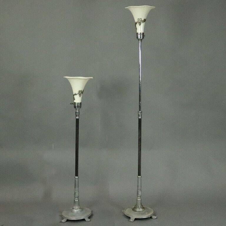 Pair of antique French Art Nouveau torchiere floor lamps feature cast metal base with acanthus leaf, beaded and claw foot design, adjustable height shaft, fluted opaline glass shade wrapped with cast metal grape and vine, newly re-wired, circa